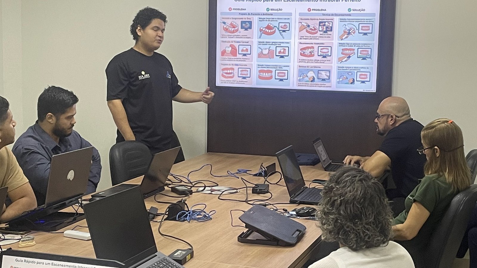Turma fazendo escaneamento intraoral com laptops na sala técnica