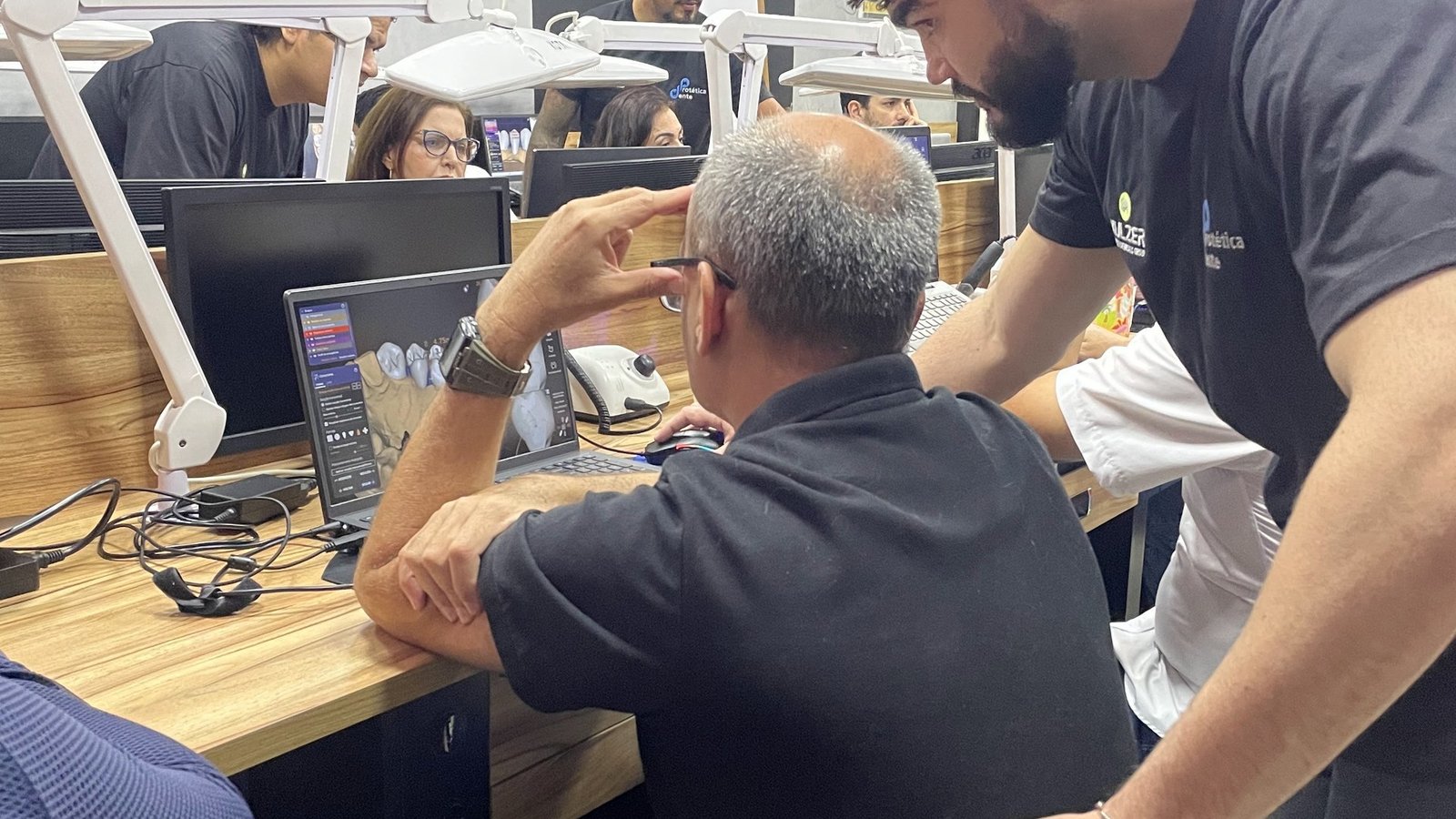 Mentor ensinando aluno em bancada — toque técnico